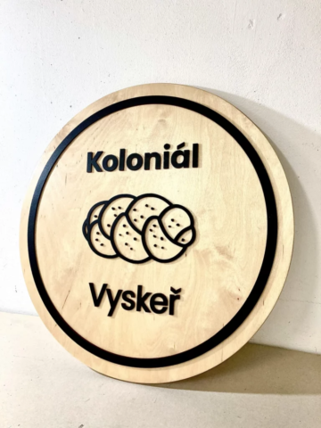 Dřevěné logo koloniál vyskeř na dřevěném kulatém podkladu