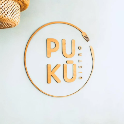 Dřevěné logo PUKU bistro na stěně v restauraci v Turnově