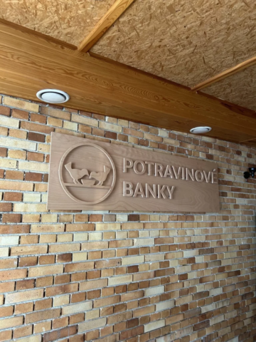 Dřevěné podsvícené logo Potravinové banky na dřevěném podkladu