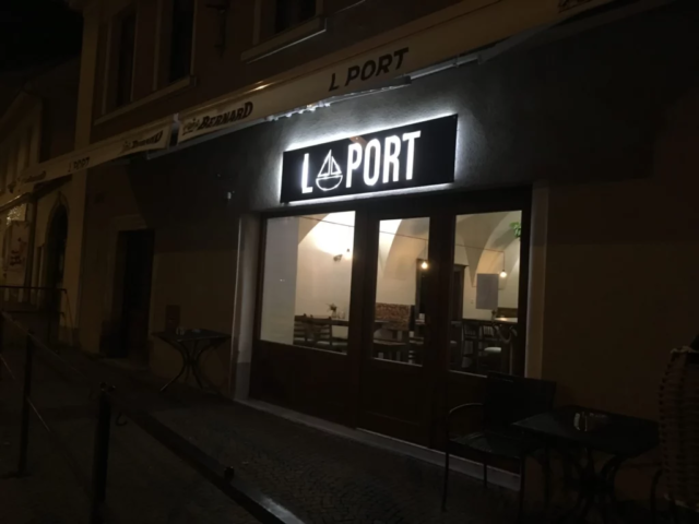 Podsvícená cedule Laport na vchodem restaurace v Turnově