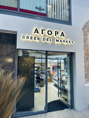 podsvícné černé logo agora greek deli market v pražském burzovním paláci