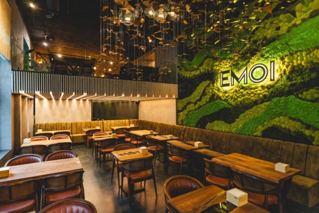 podsvicene-logo-emoi-plzen-interier Podsvícené logo Emoi na zelené stěně v interiéru restaurace v Plzni